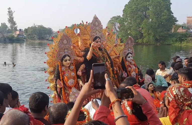 कंधे पर उठा कर विसर्जन के लिए मां दुर्गे की प्रतिमा ले जाते हैं भक्त.