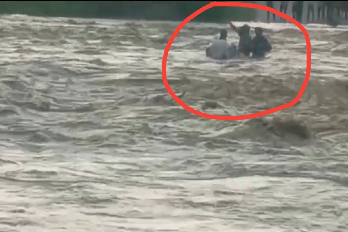 Three youths stranded in the strong currents of the Gerua River in Chatra.