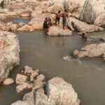 woman-trapped-rock-amidst-deep-water